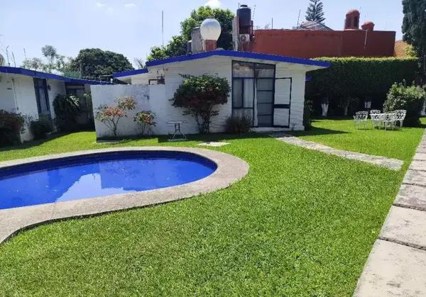 Casa con amplias areas verdes y alberca.